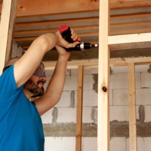 the man screws the beams for the interior partition